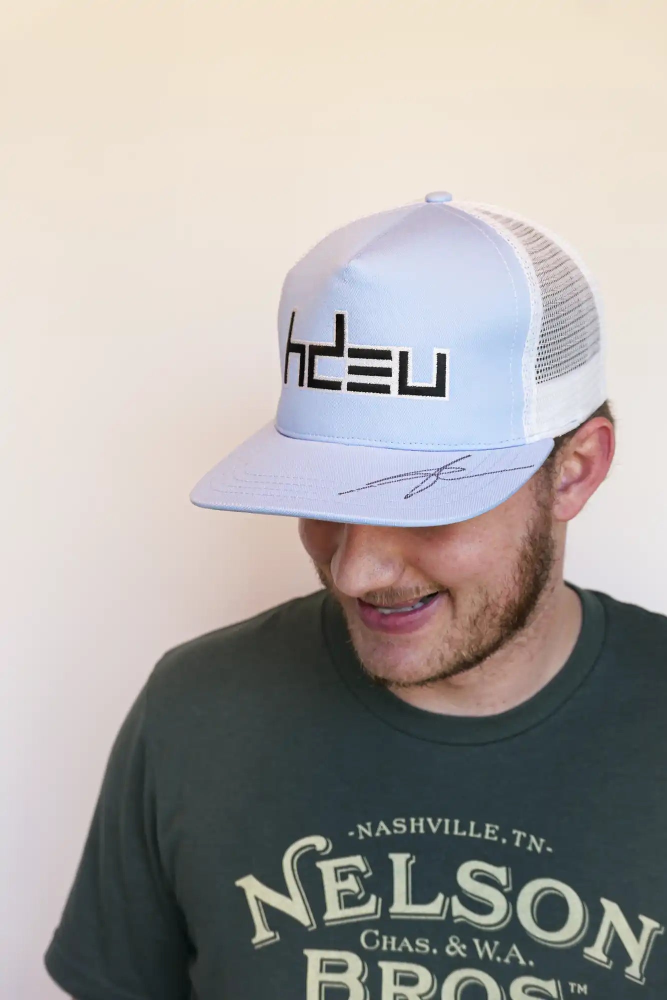 Light blue and white trucker hat with ’hDEU’ printed on the front.